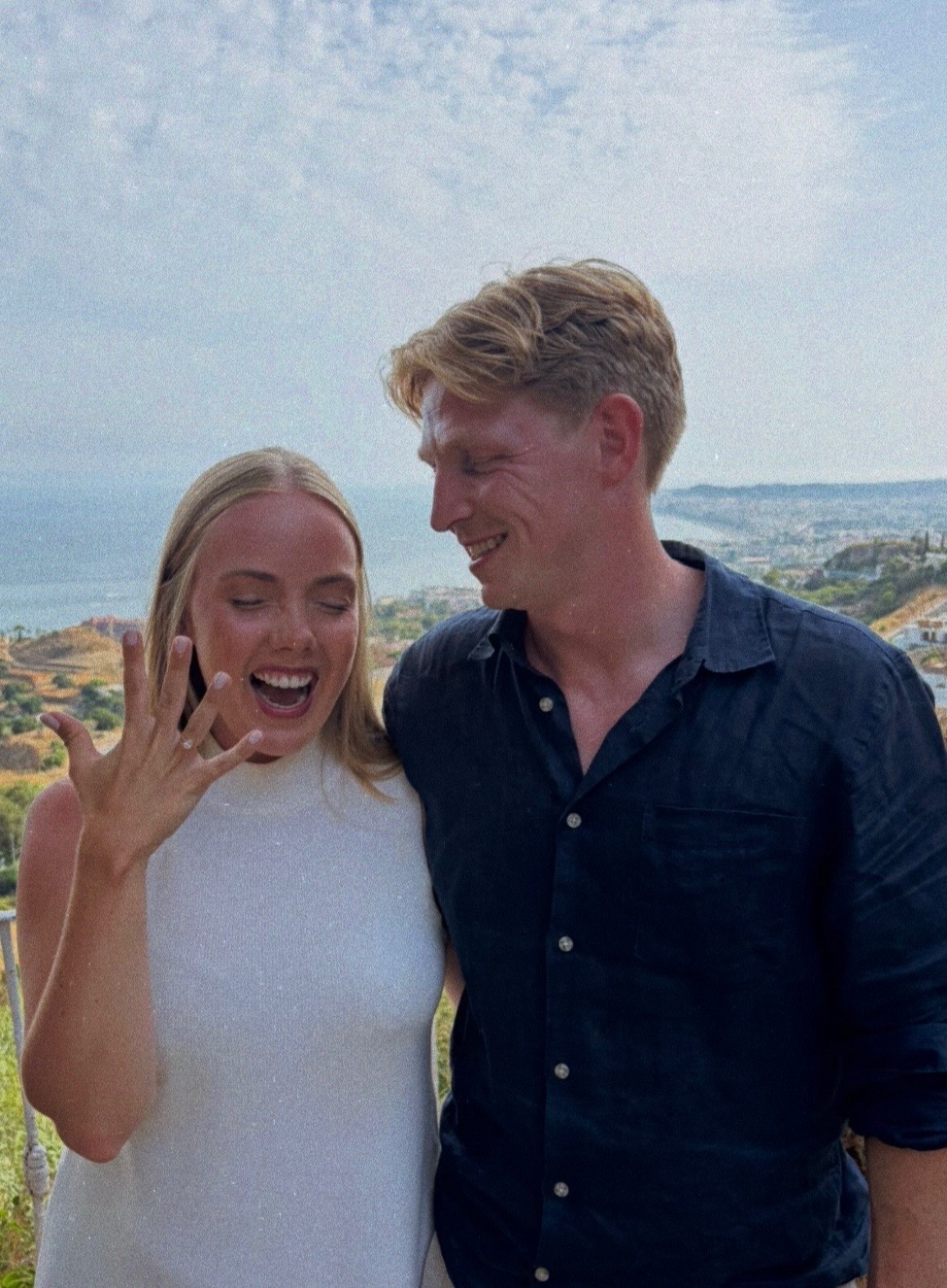 Kristoffer og Stine smiler sammen, og Stine viser frem forlovelsesringen.